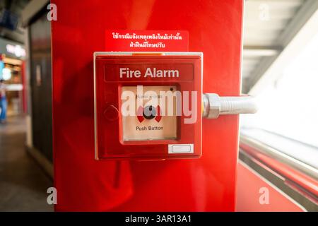 Close up of a fire alarm break glass installed inside a transport building in the case of fire in Thailand Stock Photo