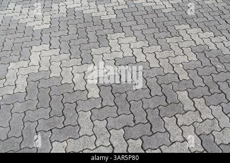 Close up of interlocking grey bricks forming a pattern in a pavement Stock Photo