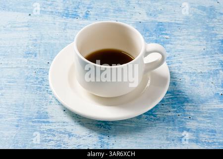 Top view of freshly brewed coffee in white porcelain cup on blue stone table Stock Photo