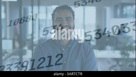 Image of numbers changing over smiling biracial businessman in office Stock Photo
