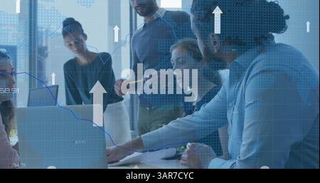 Image of upload arrows and data processing over diverse colleagues talking in office Stock Photo