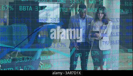 Image of finance data processing over two diverse colleagues using tablet talking in corridor Stock Photo