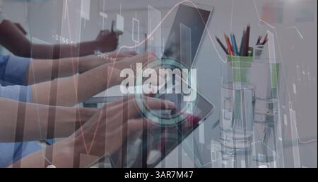 Image of diverse data and clock over hands of diverse business colleagues working on laptops Stock Photo