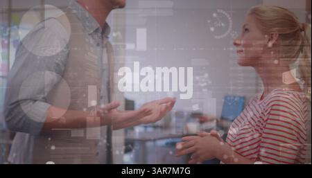Image of diverse data and clock over caucasian female and male colleagues talking in office Stock Photo