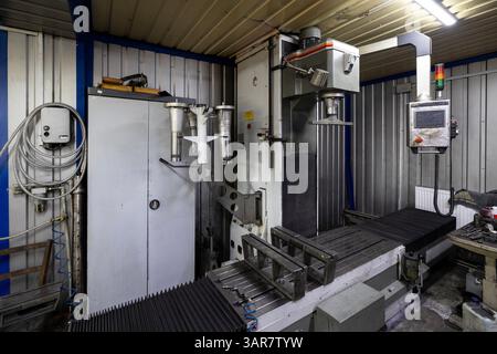 An industrial milling machine is situated within an auto repair shop that specializes in comprehensive repairs of cargo vehicles. Stock Photo