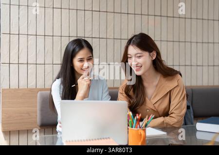 Study Break and Laughter. Two students share a light moment while collaborating on their homework. Stock Photo