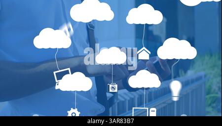 Image of clouds with electronic devices over caucasian man using smartphone Stock Photo