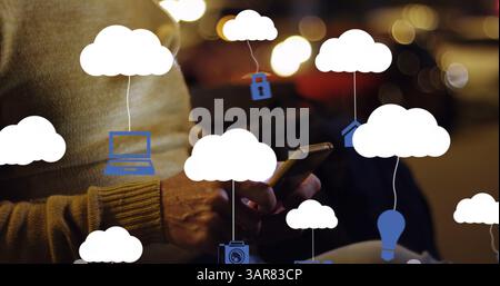Image of clouds with electronic devices over caucasian man using smartphone Stock Photo