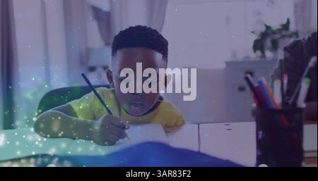 Image of lights over african american boy doing homework Stock Photo
