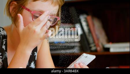 Image of rotating digital head over caucasian girl using smartphone Stock Photo
