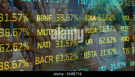 Image of financial data processing over man with tablet working in warehouse Stock Photo