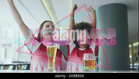 Image of you win text over happy diverse female friends raising hands and drinking beer Stock Photo