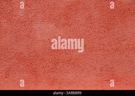The shaggy soft surface of the coral-colored case as a background close-up Stock Photo