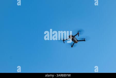 Mavic 2 drone flying above against a clear blue sky, Scotland, UK Stock Photo
