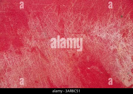 Red plastic kitchen cutting board with scratches and cuts as background close-up Stock Photo