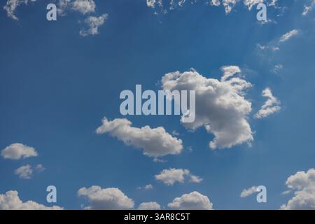 Peaceful sky with soft blue tones fluffy clouds—perfect natural background capturing serene beauty, open air, and calming atmosphere for visual escape Stock Photo