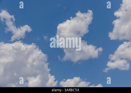 Peaceful sky with soft blue tones fluffy clouds—perfect natural background capturing serene beauty, open air, and calming atmosphere for visual escape Stock Photo