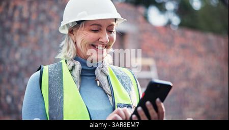 Phone, mature woman and construction worker on site with contact for renovation approval. Contractor, cellphone and female civil engineer reading Stock Photo