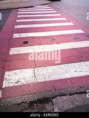 pedestrian crossing red asphalt white lines weathered cracked asphalt atmospheric background Stock Photo