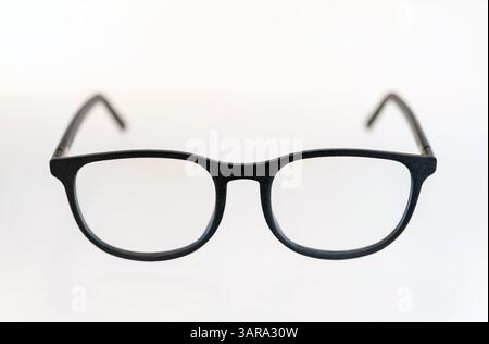 Stylish black eyeglasses sit on a clean white background, showcasing their simple and modern design Stock Photo