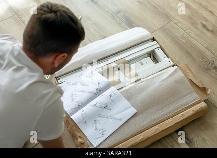 man assembling furniture at home. close up of man's hand with screwdriver Stock Photo