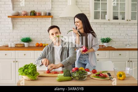 Cheerful Couple Cooking Lunch Together In The Kitchen And Having Fun At Home Stock Photo