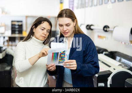 Women publishing facility workers having conversation about work Stock Photo