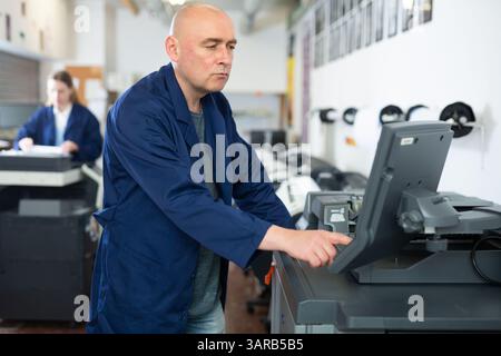 Man working in publishing facility Stock Photo