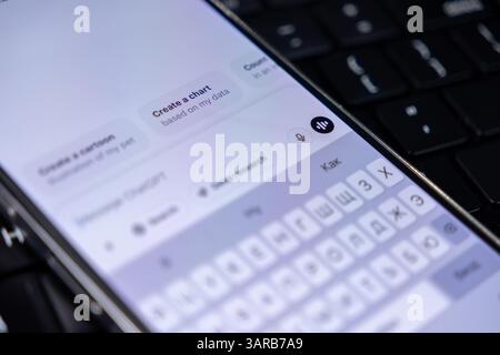 Poznan, Poland – April 14, 2025: Close-up of smartphone with ChatGPT app open, showing voice input icon, message suggestions, and digital assistant in Stock Photo