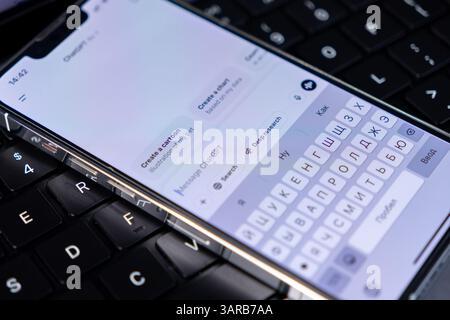 Poznan, Poland – April 14, 2025: Close-up of smartphone screen showing ChatGPT app with search tools, message field, and smart reply buttons in a tech Stock Photo