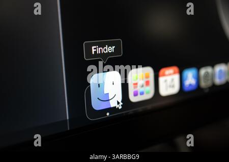 Poznan, Poland – April 14, 2025: Detailed view of macOS interface showing Finder app icon in Dock, highlighted by a cursor pointer on dark desktop bac Stock Photo