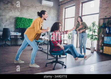 Young professionals engaging in playful and collaborative activity at a modern coworking space. Stock Photo
