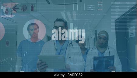 Image of graphs and data over diverse female and male doctors with x ray walking in hospital Stock Photo