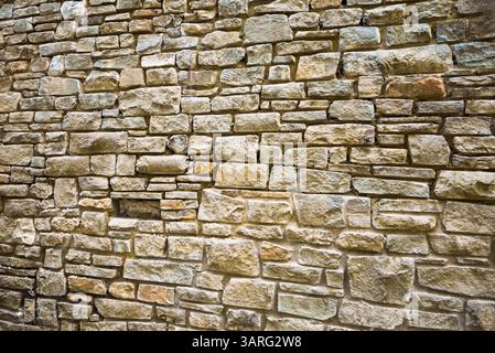 A weathered stone wall, showcasing the texture and color variations of the individual stones. Stock Photo