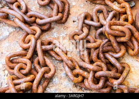 Rusty chains on stone floor on the dock in Spain Stock Photo