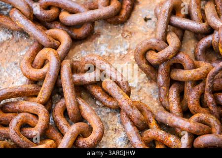 Rusty chains on stone floor on the dock in Spain Stock Photo