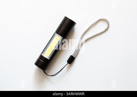 Small pocket portable black flashlight with led bulbs on white background Stock Photo