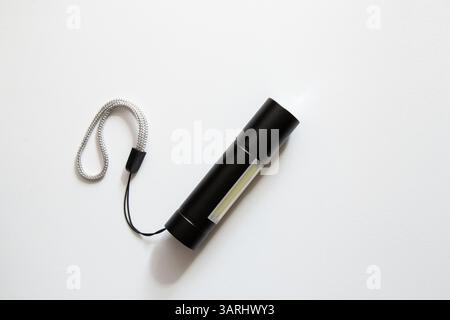 Small pocket portable black flashlight with led bulbs on white background Stock Photo