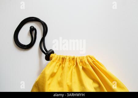 Yellow duffel bag with drawstring and clip on white background close-up, fabric bag Stock Photo