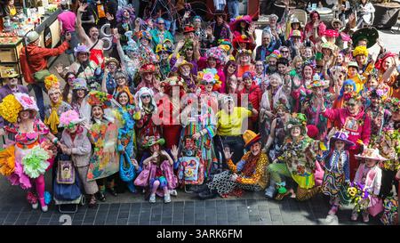 London, UK. 17th Apr, 2025. The group photo proves very popular with market visitors. The Easter Bonnet Parade of the Colour Walk Group is a fun event at Old Spitalfields Market organised with original founder, artist Sue Kreizman and organiser and designer Florent Bidois. The group informally meet once a month to celebrate all things colourful with their vibrant outfits, today the theme is the Easter Bonnet. Credit: Imageplotter/Alamy Live News Stock Photo