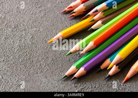 Crayons, colorful dry painting pencils on dark rustic background, back to school art design Stock Photo