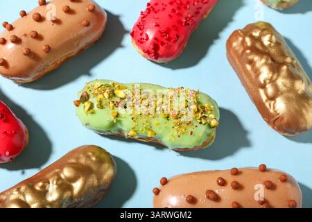 Composition with various glazed eclairs on color background Stock Photo