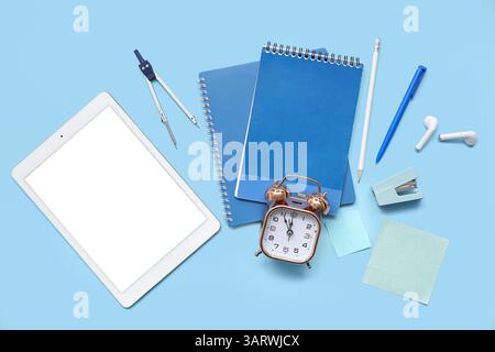 Composition with different stationery, alarm clock and modern gadgets on color background Stock Photo