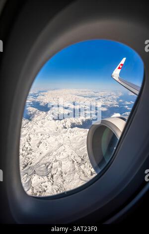 View over the snowy Swiss Alps from an airplane window Stock Photo