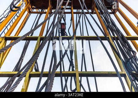 Steel cables hang from a steel structure. Stock Photo