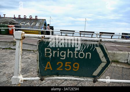 a mangled dirty old road sign directing traffic on to the A259 to ...
