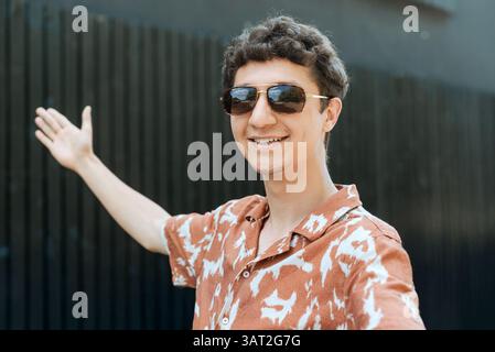 Smiling young man in sunglasses outdoors Stock Photo