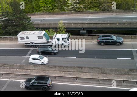 Great Barr, Birmingham, April 18th 2025. An unfortunate holidaymaker has broken down with their caravan on the back of a recovery truck on the southbound carriageway of the M5 motorway near Birmingham. - Good Friday traffic is building close to Junction 8 of the M5 and M6 motorway Interchange near Great Barr, Birmingham as motorists getaway on Good Friday. The M5 motorway (pictured) joins the M6 at Junction 8 northbound towards Wolverhampton and Southbound towards London. Credit: British News and Media/Alamy Live News Stock Photo