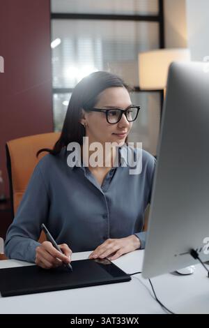 Smiling Woman using Drawing Tablet in Office Stock Photo