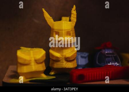 Madrid, Spain 1 June 2024 A collection of 3d-printed Pokemon figures, a primary focus on a yellow Pikachu-like model, captured in a low-light setting. Stock Photo